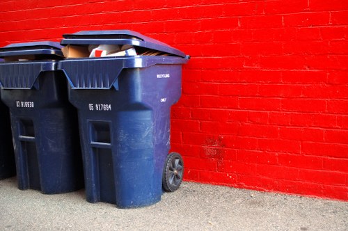 Operative wearing PPE standing beside a skip